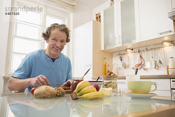 sitzend Mann lächeln Küche Tisch Frühstück