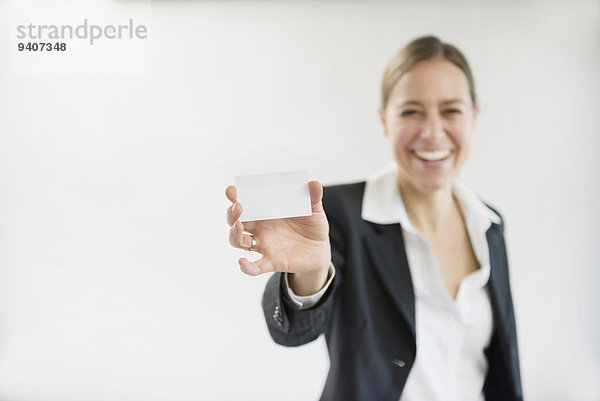 Portrait Geschäftsfrau lächeln halten schwarz Anzug unbeschrieben Business Karte