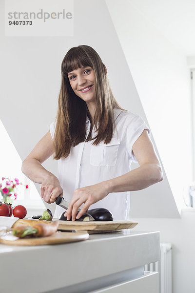 Portrait Frau lächeln schneiden Küche Mittelpunkt Aubergine Erwachsener