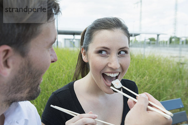 Außenaufnahme Fröhlichkeit Sushi essen essend isst freie Natur