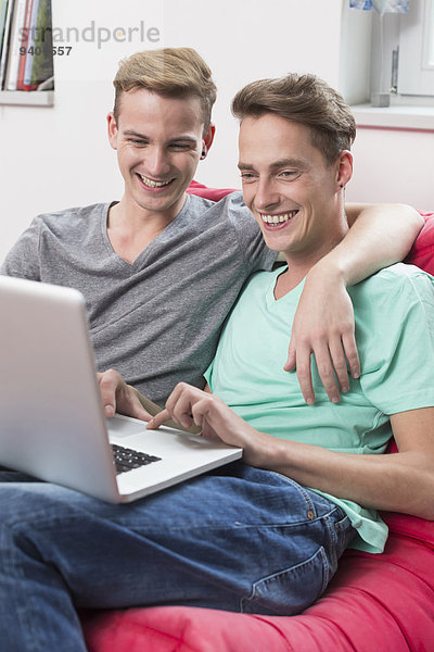 benutzen Notebook lächeln Homosexualität Couch
