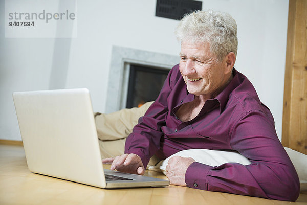 Senior Senioren benutzen Mann Notebook lächeln Zimmer Wohnzimmer
