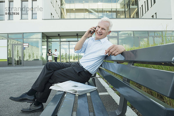 sitzend benutzen Geschäftsmann Sitzbank Bank Smartphone