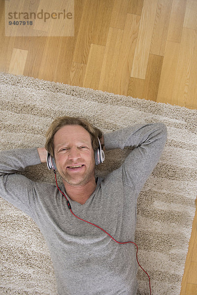 liegend liegen liegt liegendes liegender liegende daliegen Mann zuhören Entspannung Musik Teppichboden Teppich Teppiche Klassisches Konzert Klassik