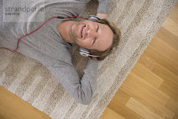liegend liegen liegt liegendes liegender liegende daliegen Mann zuhören Entspannung Musik Teppichboden Teppich Teppiche Klassisches Konzert Klassik