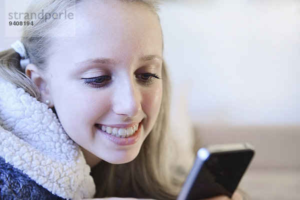 benutzen Jugendlicher lächeln Couch Smartphone Mädchen