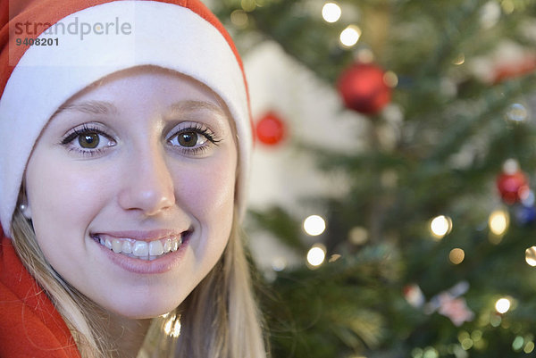 Portrait Jugendlicher lächeln frontal Weihnachtsbaum Tannenbaum Mädchen