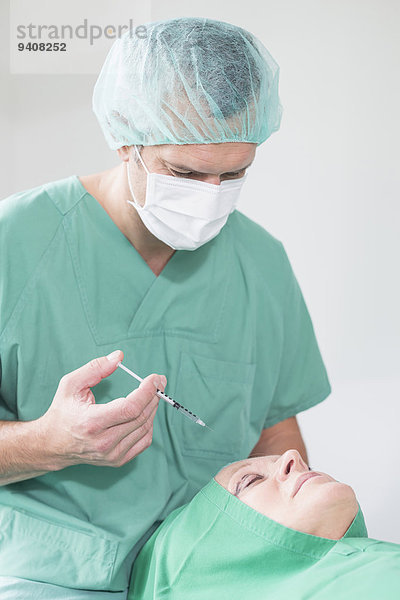 Surgeon in hospital  injecting patient