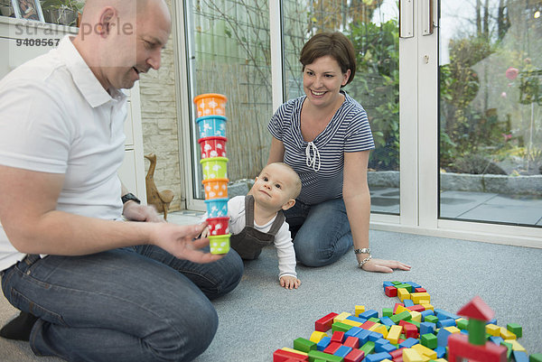 sitzend Zusammenhalt Sohn Zimmer klein Menschliche Eltern Boden Fußboden Fußböden Wohnzimmer spielen