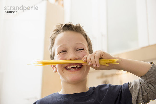 lächeln Junge - Person unterhalb halten Spaghetti