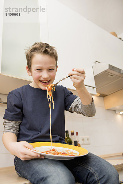 Junge - Person Küche Spaghetti essen essend isst Tresen