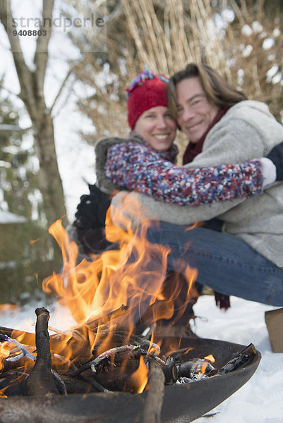 sitzend Winter lächeln Feuer