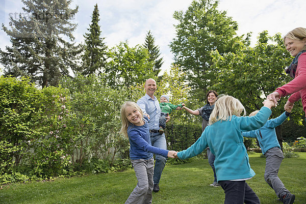 Menschliche Eltern Rasen tanzen Garten