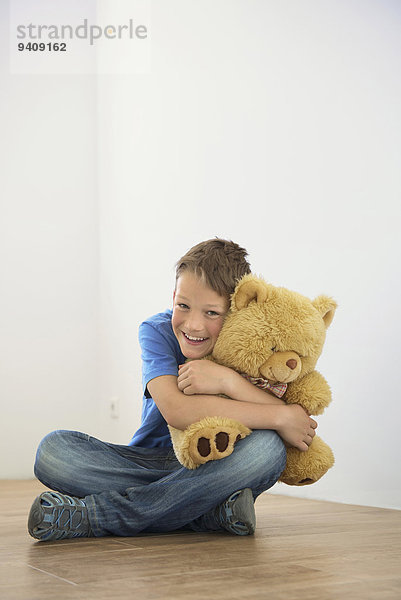 Fröhlichkeit Junge - Person halten Spielzeug Teddy Teddybär jung Eigentumswohnung neues Zuhause