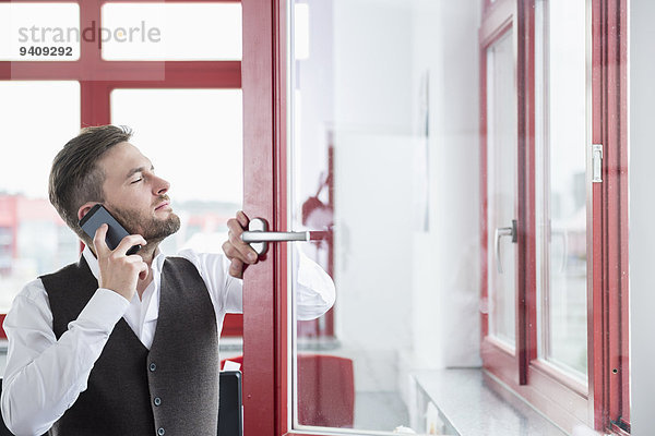 benutzen Mann Fenster offen Büro jung Smartphone