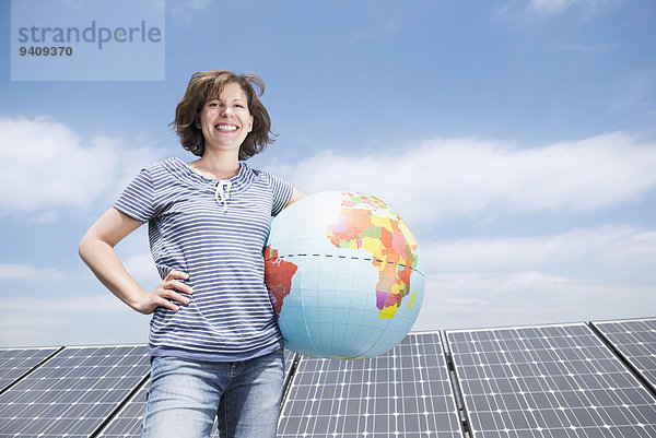 Frau Energie energiegeladen lächeln Sonnenkollektor Sonnenenergie Tisch Globus
