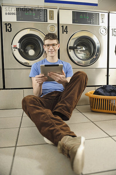 benutzen Mann lächeln jung Tablet PC Wäsche