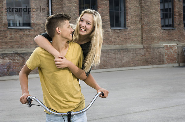 Jugendlicher umarmen lächeln Fahrrad Rad