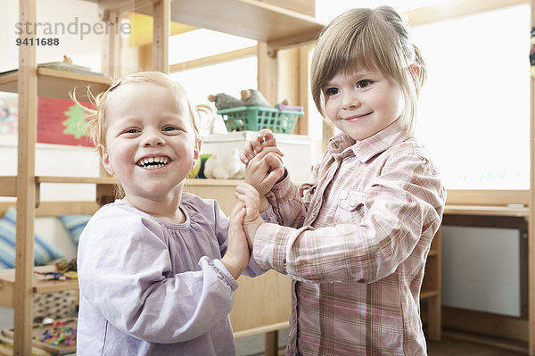 Kindergarten lächeln klein halten 2 Mädchen