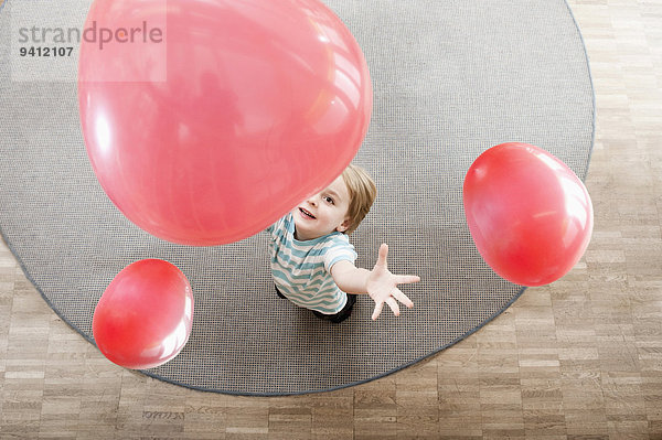 Erhöhte Ansicht Aufsicht Kindergarten Junge - Person klein Luftballon Ballon rot spielen