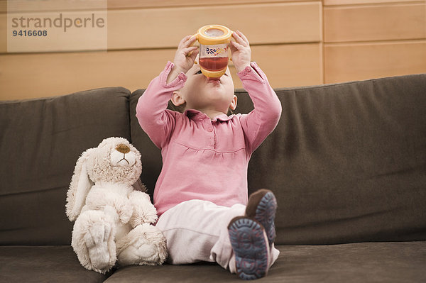 sitzend Couch trinken Saft Mädchen Baby