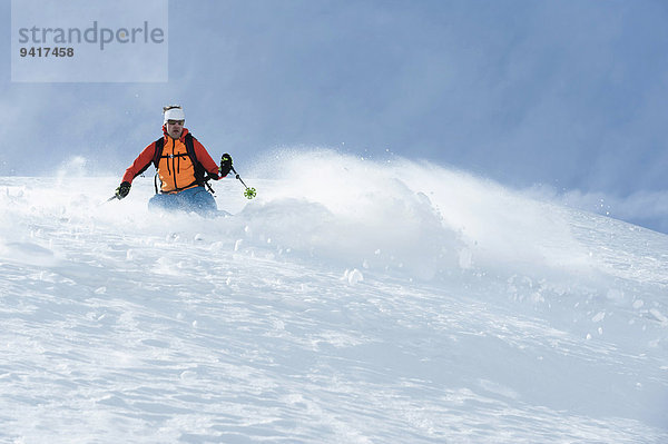 Mann Alpen Skisport Pulverschnee Gesichtspuder tief Schnee