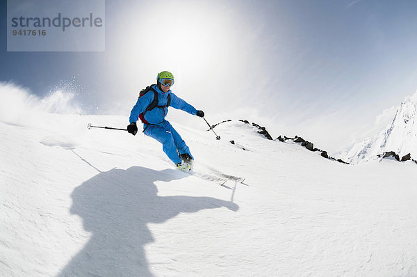 Mann Sonnenstrahl Skifahrer Skisport Hang steil