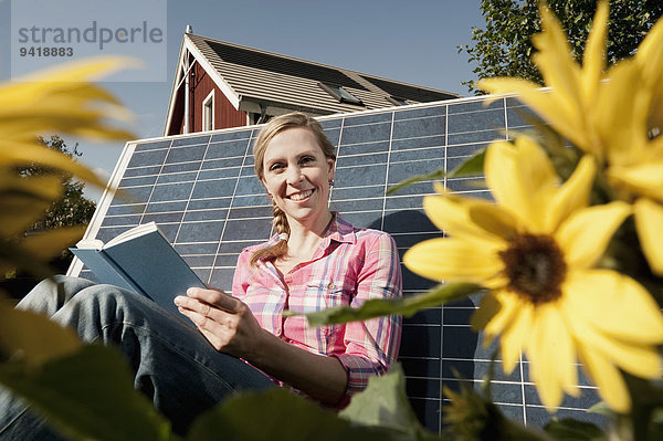 angelehnt Frau Buch Sonnenkollektor Sonnenenergie Tisch Taschenbuch vorlesen