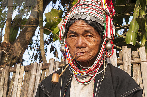 Traditionell gekleidete ältere Frau aus Akha  Bergstamm oder Bergvolk  ethnische Minderheit  mit Pfeife  Portrait  Provinz Chiang Rai  Nordthailand  Thailand