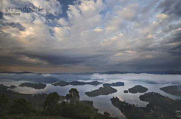 Dramatische Wolken und Nebel bei Sonnenaufgang über Inseln des Bunyonyi-Sees  Kisoro  südwestliches Uganda
