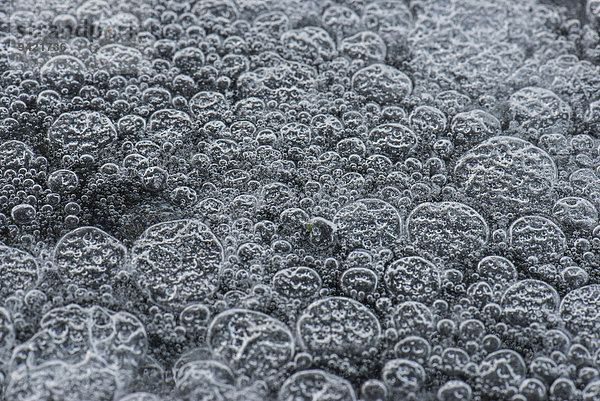 Gefrorene Luftblasen in weißem Eis