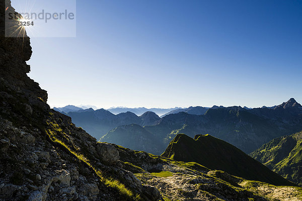 Gestaffelte Gipfel der Allgäuer Alpen am frühen Morgen mit Sonnenstern  Oberstdorf  Bayern  Deutschland