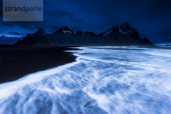 Berggipfel mit Meeresbrandung zur blauen Stunde  Höfn  Island