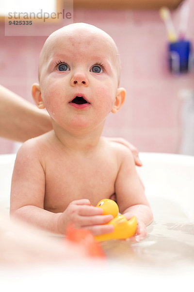 Baby  9 Monate  wird in einer Babywanne gebadet