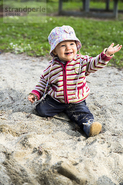 Baby  12-14 Monate  spielt im Sand