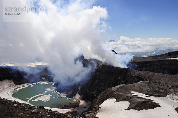 Das Innere eines Vulkans  mit türkisfarbenen Kratersee und daneben aufsteigender heisser Wasserdampf  Vulkan Goreli  Kamtschatka  Russland