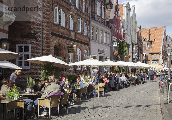 Menschen sitzen draußen vor Restaurants  Am Stintmarkt  Lüneburg  Niedersachsen  Deutschland