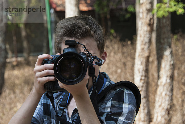 Jugendlicher fotografiert mit professioneller Kamera