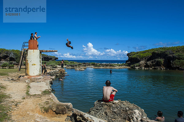 Einheimische Jungen springen und schwimmen im Salugula Pool  Guam  US-Territorium  Pazifik