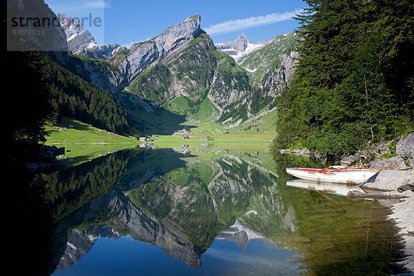 Morgenruhe mit Wasserspiegelung am Seealpsee mit Blick zum Säntis und zwei Ruderboote im Vordergrund  Alpstein  Appenzell  Schweiz  Europa