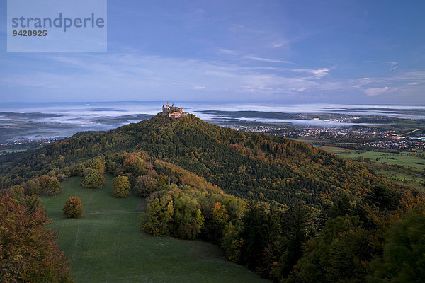 Die Burg Hohenzollern im Morgenlicht mit Herbstwald  Frühnebel  Schwäbische Alb  Baden-Württemberg  Deutschland  Europa