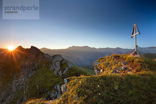 Gipfelkreuz und Sonnenaufgang im Kanton Glarus  Schweizer Alpen  Schweiz  Europa