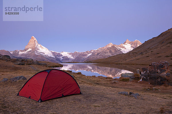 Rotes Zelt im ersten Morgenlicht am Stellisee mit Blick auf das Matterhorn  Zermatt  Wallis  Schweiz  Europa