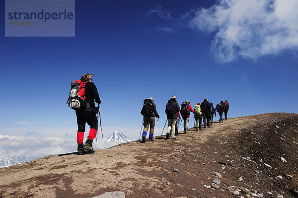Wandergruppe marschiert entlang dem Vulkankraterrand  Vulkan Goreli  Kamtschatka  Russland