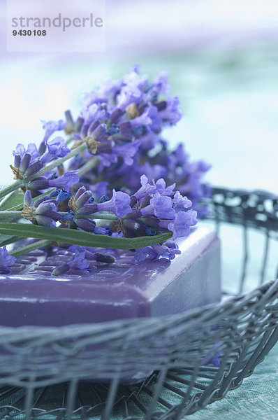 Lavendelblüten und Seife in einem Drahtkorb