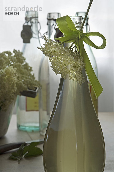 Holunderblüten und Flasche Holundersirup