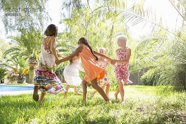 Fünf Mädchen spielen Ring ein Ring ein Rosen im Garten