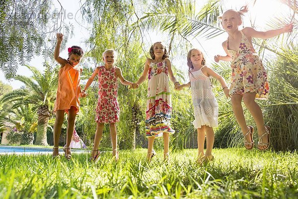 Fünf Mädchen energetische Mädchen springen im Garten