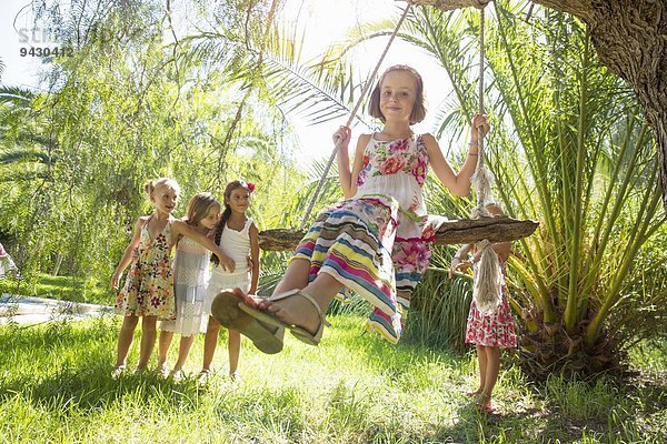 Mädchen stehen Schlange für Baumschaukel im Garten