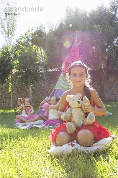 Porträt eines Mädchens mit Teddybär vor dem Tipi